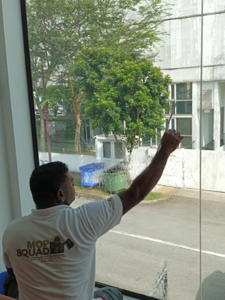 guy cleaning the big window with a squeegee