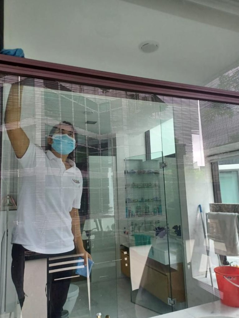 a person cleaning the window in the bathroom